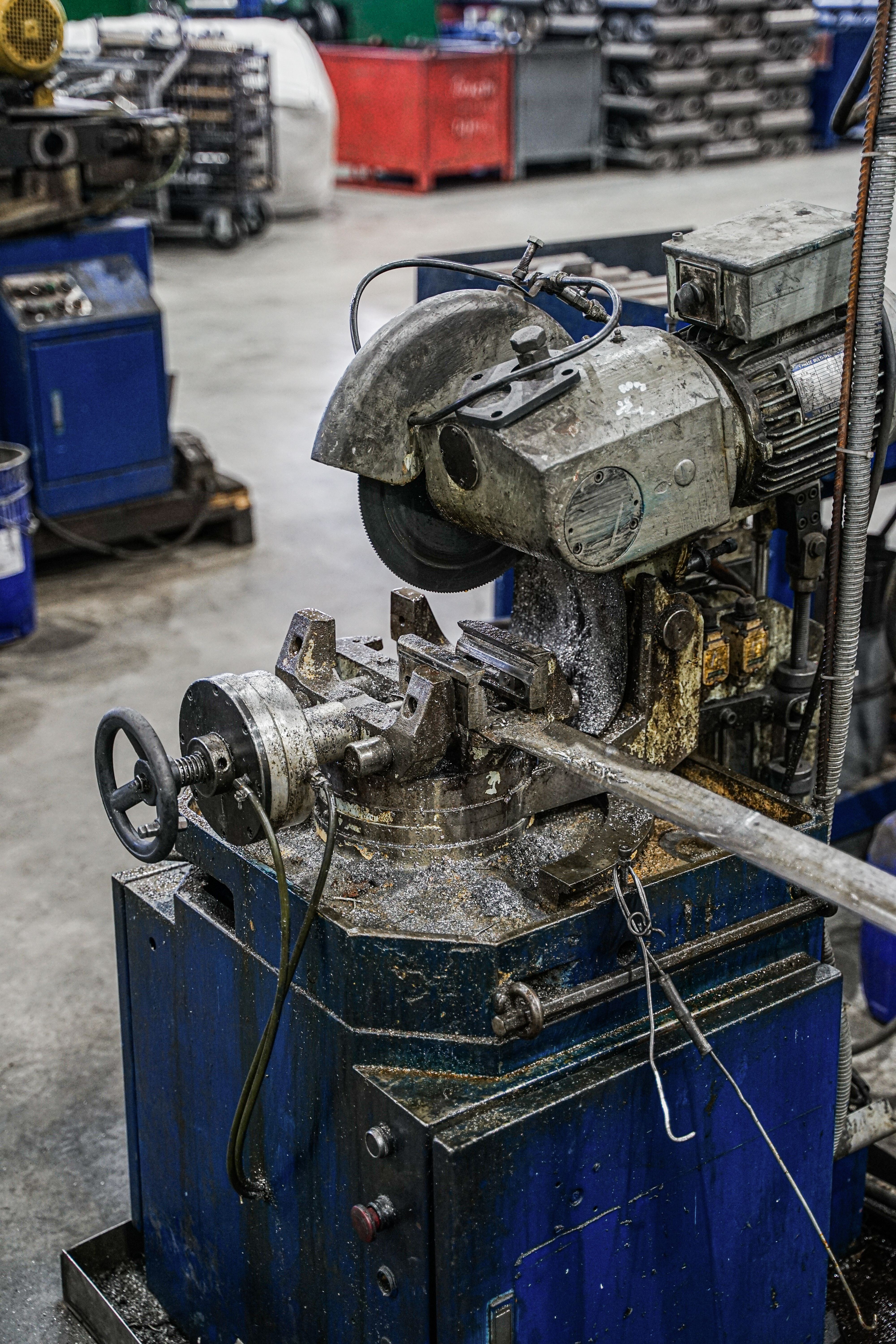 Industrial machine cutting pipe in a workshop