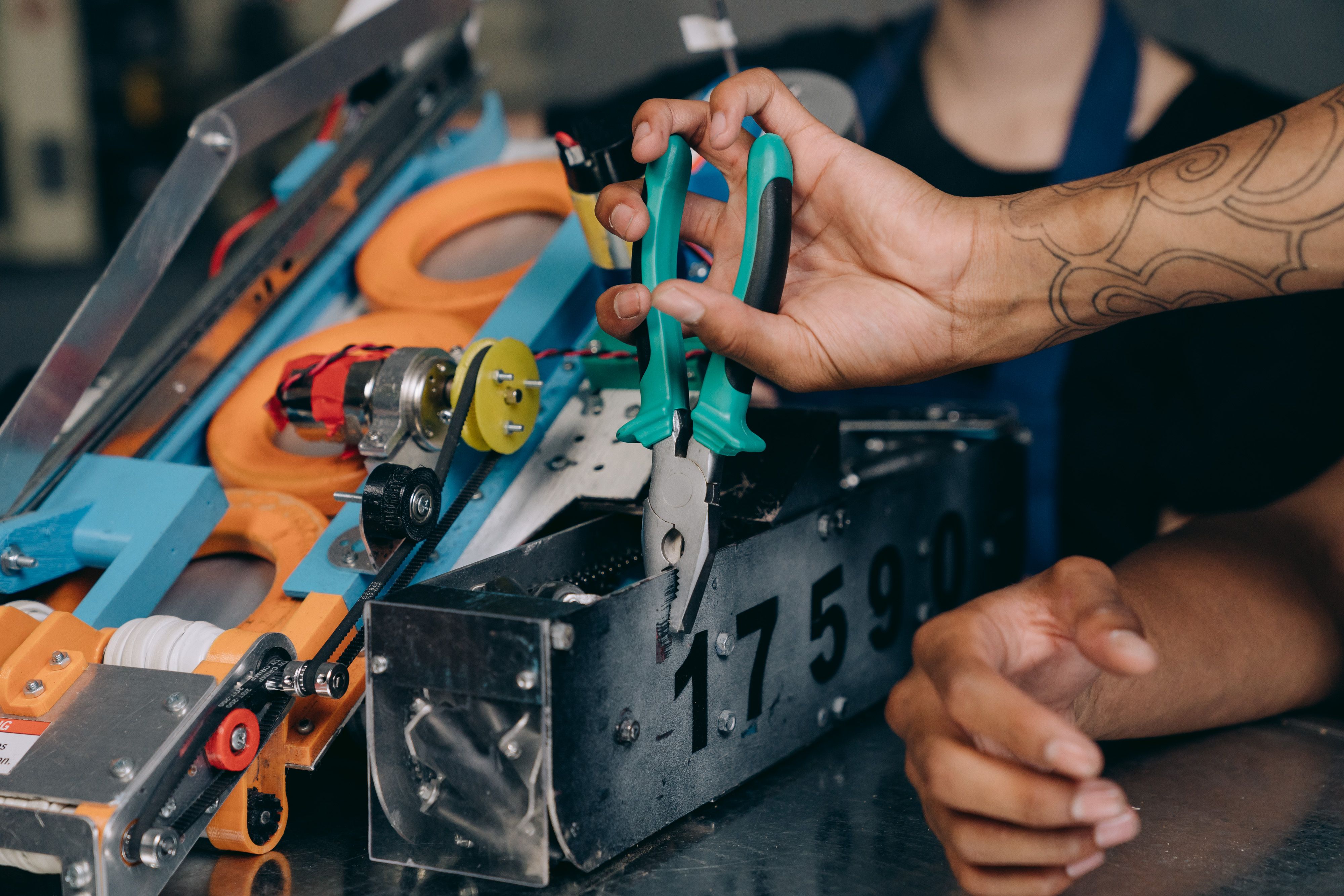 Close-up of hands repairing industrial machinery with precision tools